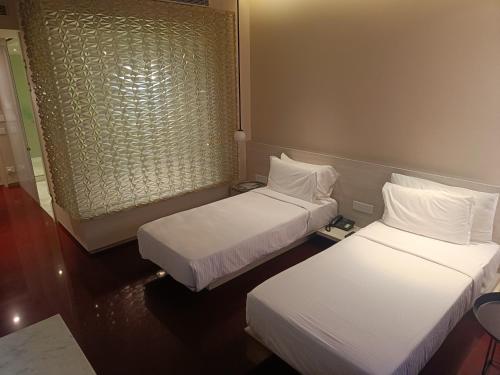 a hotel room with two beds and a window at Boulevard by Design Hotel Chennai in Chennai