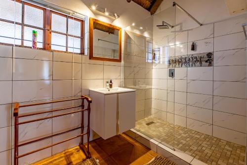 uma casa de banho com um lavatório e um chuveiro em Royal Bakoena Hamiltonparks Country Lodge em Hazyview