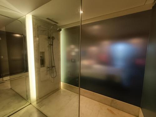 a bathroom with a shower with a glass door at Boulevard by Design Hotel Chennai in Chennai