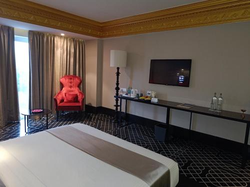 a hotel room with a bed and a chair at Boulevard by Design Hotel Chennai in Chennai