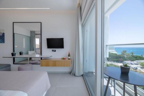 a white living room with a view of the ocean at Napa Mermaid Hotel & Suites in Ayia Napa