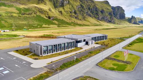 an aerial view of a building in front of a mountain at Hótel Kría in Vík