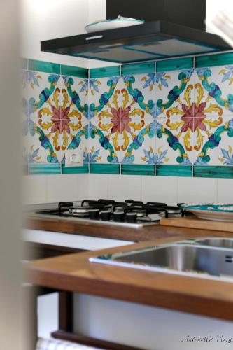 a kitchen with a sink and a tile wall at Casa Maddy Amalfi Coast in Atrani