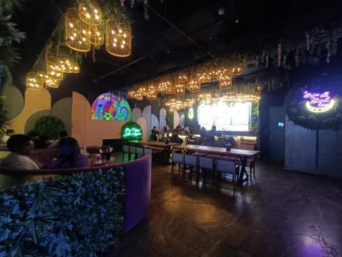 a restaurant with tables and chairs and chandeliers at Boulevard by Design Hotel Chennai in Chennai