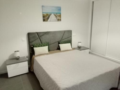 a bedroom with a large bed with two night stands at Alburvillage A - Apartamento Novo em Alvor in Alvor