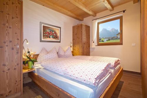 a bedroom with a bed and a window at Apartments Cornelia in Castelrotto