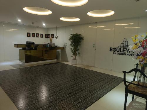 a lobby of a building with a large rug at Boulevard by Design Hotel Chennai in Chennai