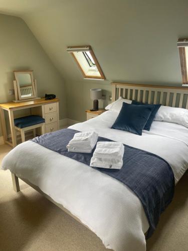 een slaapkamer met een groot bed en handdoeken bij The Red Lion Charing Heath in Charing
