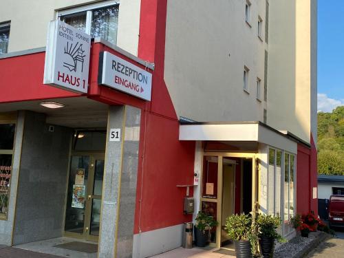 un edificio rojo y blanco con un letrero para un taller de reparación en Hotel Sonne - Haus 1 en Idstein