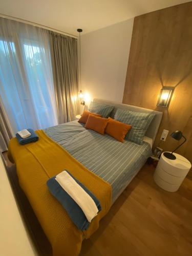 a bedroom with a bed with a yellow blanket at Premium Lelle Waterfront Resort Bonnie in Balatonlelle