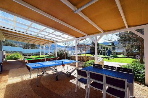 a covered patio with a ping pong table and chairs at פלאז'ה בוטיק in Peqi‘in H̱adasha