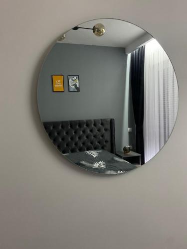 a mirror on a wall with a couch in a room at DAF apartaments in Pristina