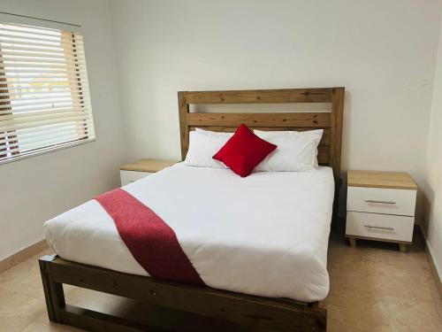 Un dormitorio con una cama grande con una almohada roja. en Gukurume- Gaborone, en Gaborone