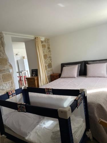 une chambre avec un lit et un mur en pierre dans l'établissement Menton Mignon 2p bucolique vue mer campagne, à Menton