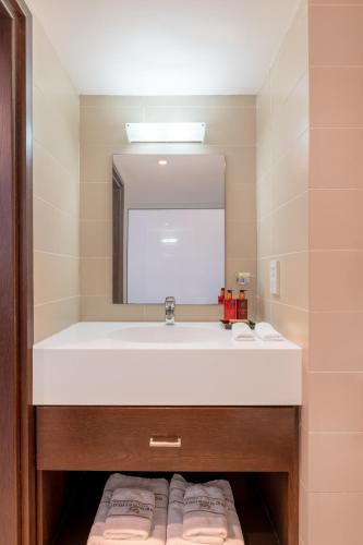 a bathroom with a white sink and a mirror at Napa Mermaid Hotel & Suites in Ayia Napa