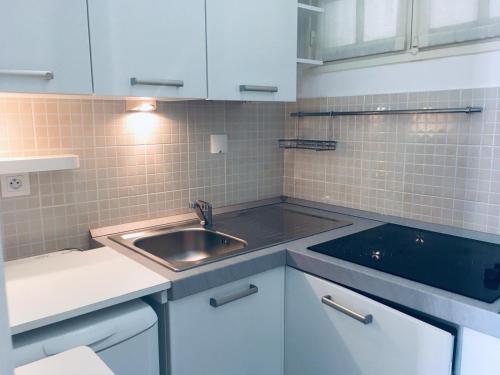 a small kitchen with a sink and white cabinets at Gabriella in Menton