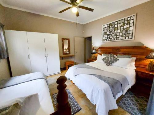 sypialnia z 2 łóżkami i wentylatorem sufitowym w obiekcie InnibosRus Self-catering w mieście White River