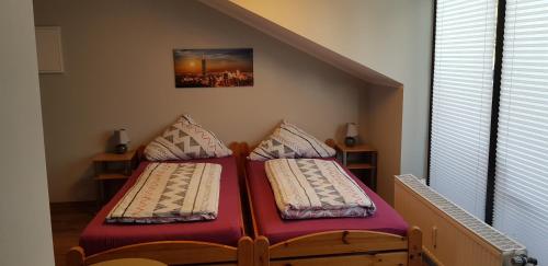 two twin beds in a room with a staircase at Pension Strohm im Lieth Café in Bad Fallingbostel