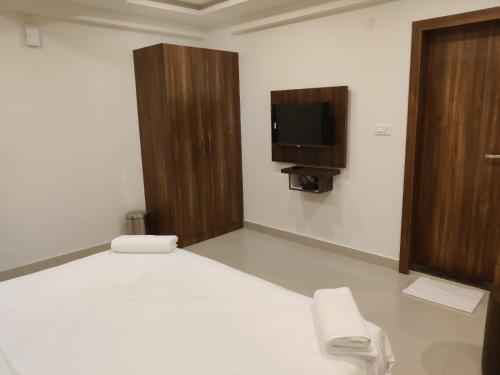 a bedroom with a bed and a tv on the wall at Relax Inn in Bengaluru