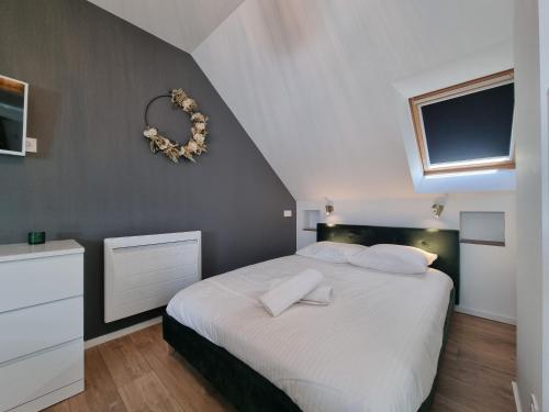 - une chambre avec un grand lit blanc et une fenêtre dans l'établissement Le Cœur d’Artichaut by Madame Conciergerie, à Bruz