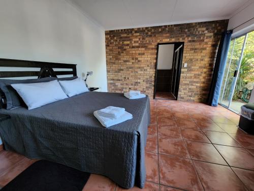 a bedroom with a bed and a brick wall at Casa Tomar Unit in Mataffin