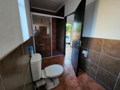 a bathroom with a toilet and a shower at Casa Tomar Unit in Mataffin