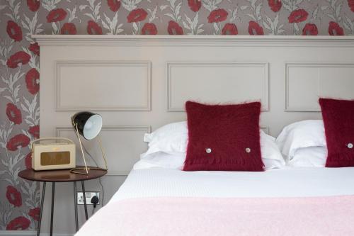 a bedroom with a bed with red pillows and a table at The Florentine in Sheffield