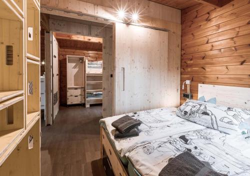 destinature Dorf Südeifel في Ernzen: غرفة نوم بسرير كبير وبجدار خشبي
