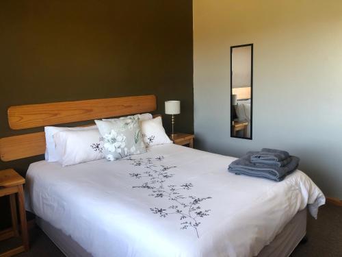 Un dormitorio con una gran cama blanca con flores. en Inn On Highlands, en Grabouw
