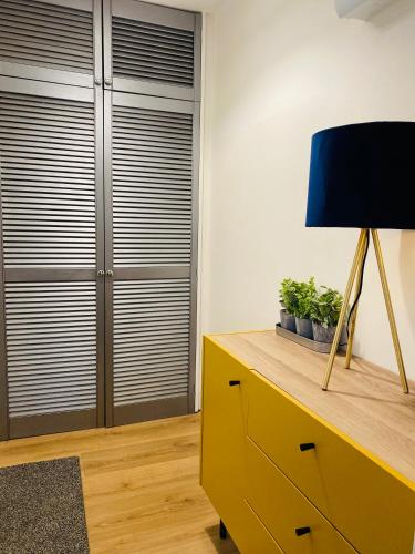 a living room with a yellow dresser and a lamp at HAYDEN - KENILWORTH STUDIO FLAT 30 m2 - PRIVATE PARKING in Kenilworth