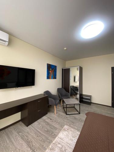 ein Wohnzimmer mit einem großen Flachbild-TV in der Unterkunft Hotel Atmosphere in Poltawa