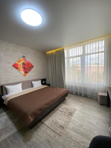 a bedroom with a bed and a large window at Hotel Atmosphere in Poltava