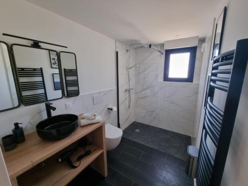 een badkamer met een wastafel, een toilet en een douche bij L'Effet Papillon by Madame Conciergerie in Bruz