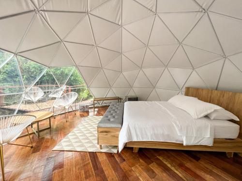 1 dormitorio con 1 cama y una pared de triángulos en Solana Glamping, en Pereira