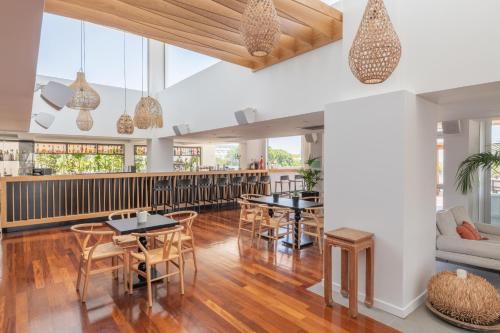 a dining room with tables and chairs and a bar at Napa Mermaid Hotel & Suites in Ayia Napa