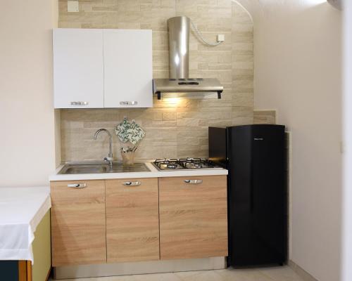 eine Küche mit einem schwarzen Kühlschrank und einer Spüle in der Unterkunft Casa Masaniello in Martina Franca