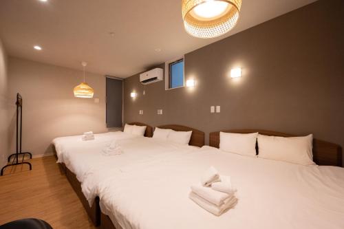 a bedroom with a large white bed with towels on it at Hotel AZUMA SEE in Tokyo