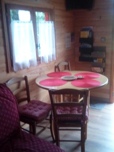 a room with two tables and chairs and a window at Les Insolites de Nini in Grainville-Ymauville