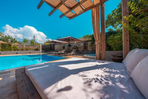 a swimming pool in a backyard with a wooden pergola at VILLAS KAYAKOY 1 OLUDENIZ/FETHIYE in Kayakoy