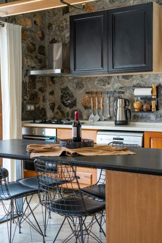 a kitchen with black cabinets and a table with chairs at VILLAS KAYAKOY 1 OLUDENIZ/FETHIYE in Kayakoy
