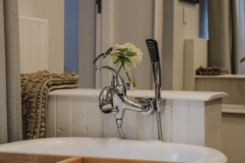 a bathroom sink with a faucet and a flower on a counter at Linkview House in Frankfort