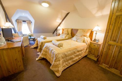 a bedroom with two beds and a desk at The King William IV Country Inn & Restaurant in Sedgeford