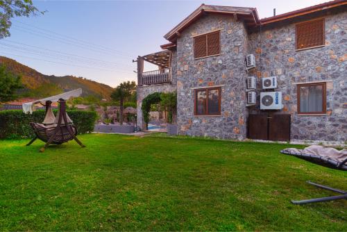 a stone house with a yard in front of it at VILLAS KAYAKOY 1 OLUDENIZ/FETHIYE in Kayakoy