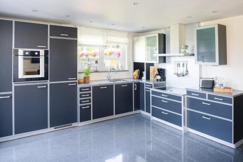 een grote keuken met blauwe kasten en apparaten bij Kurviertel Wohnung I in Überlingen