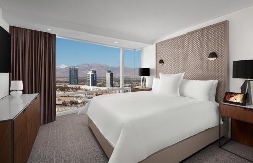 een slaapkamer met een groot wit bed en een groot raam bij ARIA Resort & Casino in Las Vegas