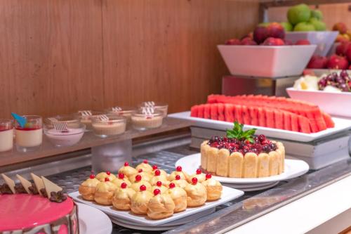 a buffet with cakes and other desserts on plates at Napa Mermaid Hotel & Suites in Ayia Napa