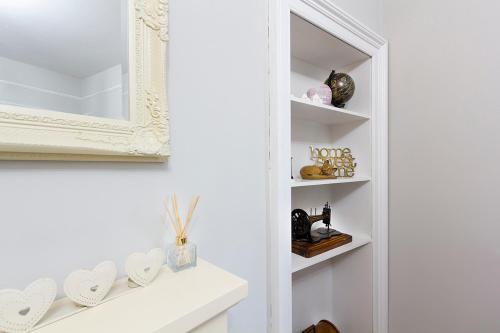 a bathroom with a mirror and a white shelf at Cosy near centre Edinburgh apartment in Edinburgh