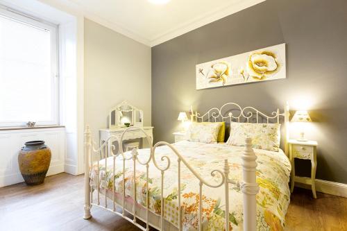 a bedroom with a bed with a white bed frame at Cosy near centre Edinburgh apartment in Edinburgh