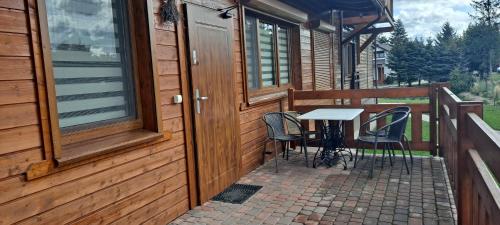 a porch with chairs and a table on a house at Apartamenty Nad Stawem in Powidz