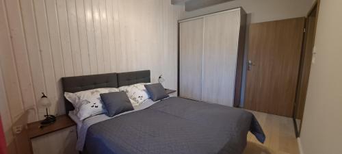 a bedroom with a bed with blue sheets and pillows at Apartamenty Nad Stawem in Powidz
